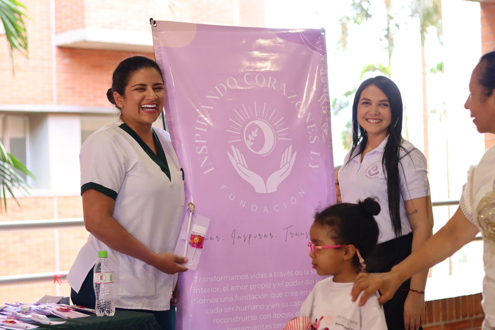 Integrantes de la fundación junto a una niña y el estandarte de la fundación